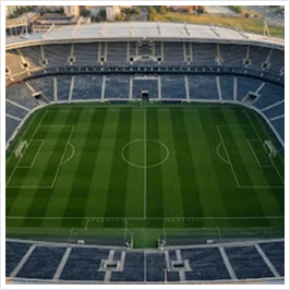 Vista aérea de cima de um estádio de futebol vazio com relvado verde e bancadas